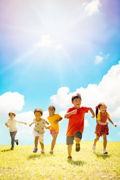 Multi-ethnic group of school children laughing and running