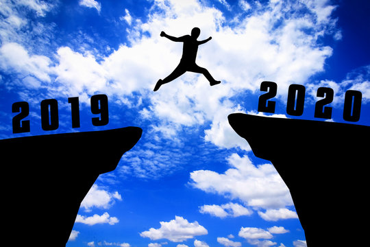 Silhouette young man jumping from 2019 to 2020 years