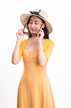 A woman in a yellow dress with a hat and sunglasses