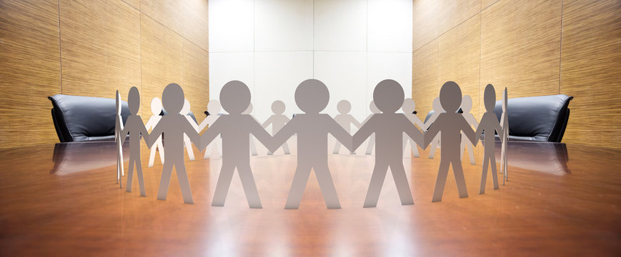 paper figurines hand in hand on office table