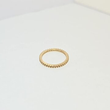 散石如红宝石、祖母绿、蓝宝石等。有一个金戒指镶嵌在白色纸张背景上。珠宝店营销照片