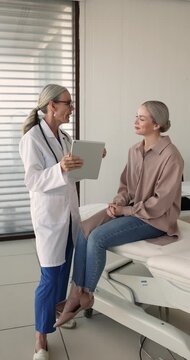 资深老医生向一位女士解释诊断结果和医学检查结果