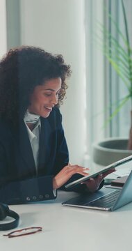 办公室里的平板电脑、笔记本电脑与女商人，为金融报告研究股票市场。开心的女性金融分析师在工作场所撰写投资提案。