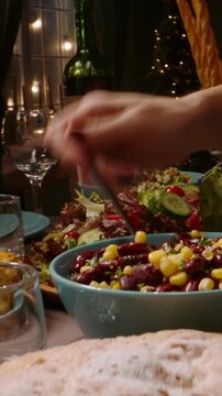 垂直慢动作视频，节日晚宴上人们上菜、倒酒，镜头扫过餐桌，展现假日庆祝的概念，适用于感恩节或圣诞节家庭盛宴，营造温馨氛围。