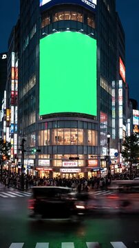 在日本东京繁华十字路口的现代化建筑上，带有用于广告的绿色屏幕大型广告牌，有交通、人群，场景有3种扭曲、叠加、故障、静态噪点、黑色扫描线效果