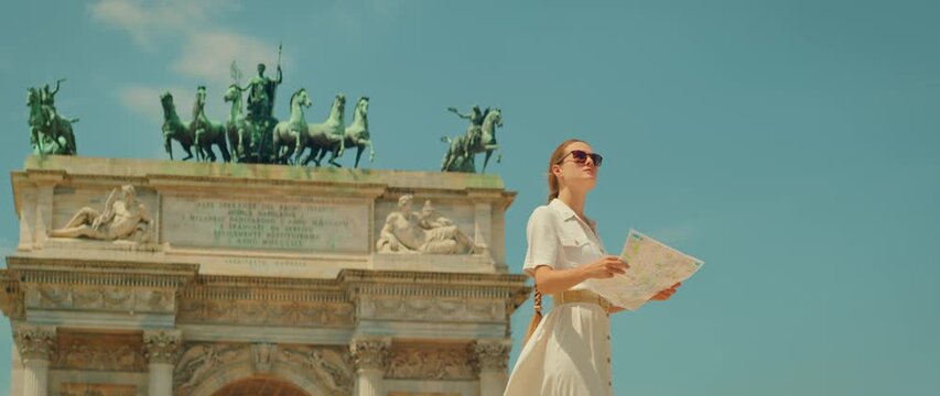 在意大利米兰市的拱门纪念碑前看地图探索旅游景点的女子