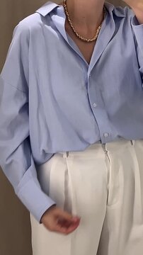 身着蓝色衬衫和米色裤子的简约装扮女性