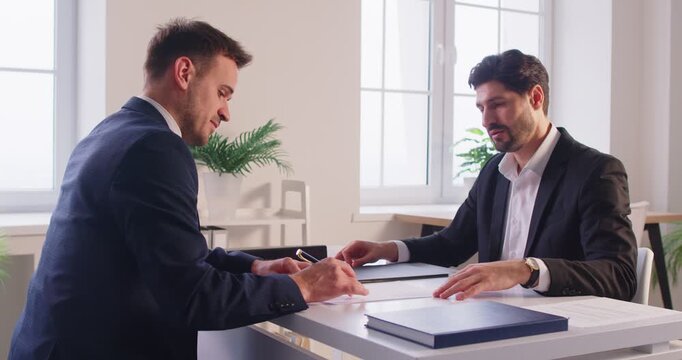 Businessmen giving hand shake in office, signing new contract agreement, skilled lawyer, financial advisor showing place signature on paper document, male client at meeting in office, agreement deal