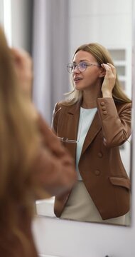 女子在镜子前试戴新眼镜